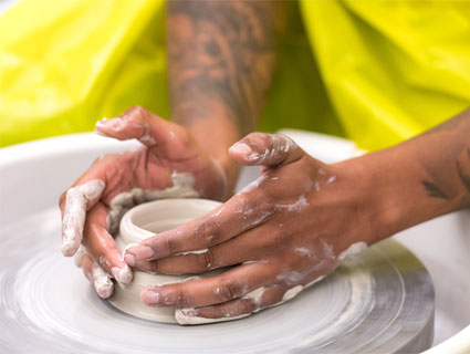 Clay-Classes Hands of someone using the pottery wheel