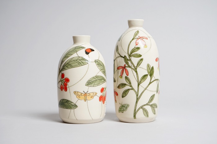 Two ceramic vases decorated with plants and insects