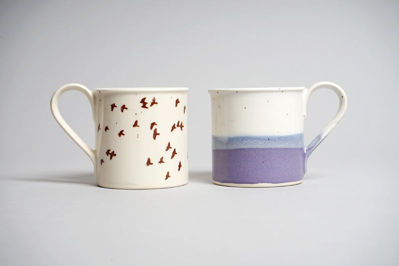Two white ceramic mugs with decoration