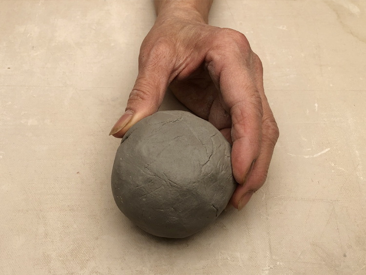 Hand holding a ball of clay