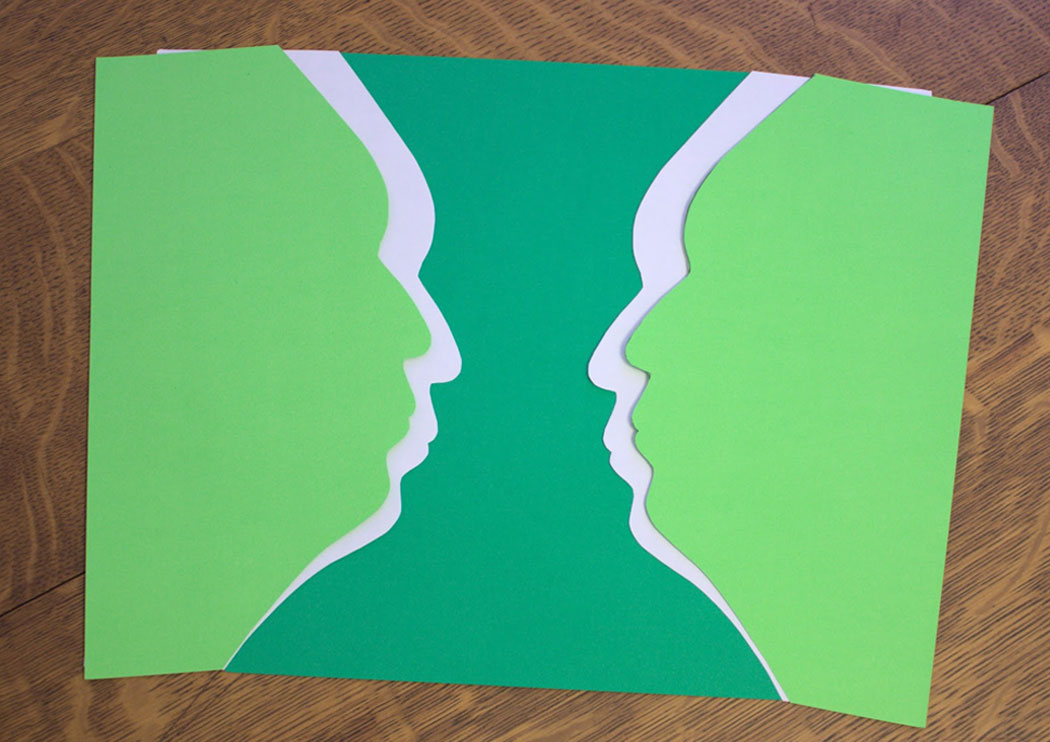 Two silhouettes of a face forming a vase in the negative space