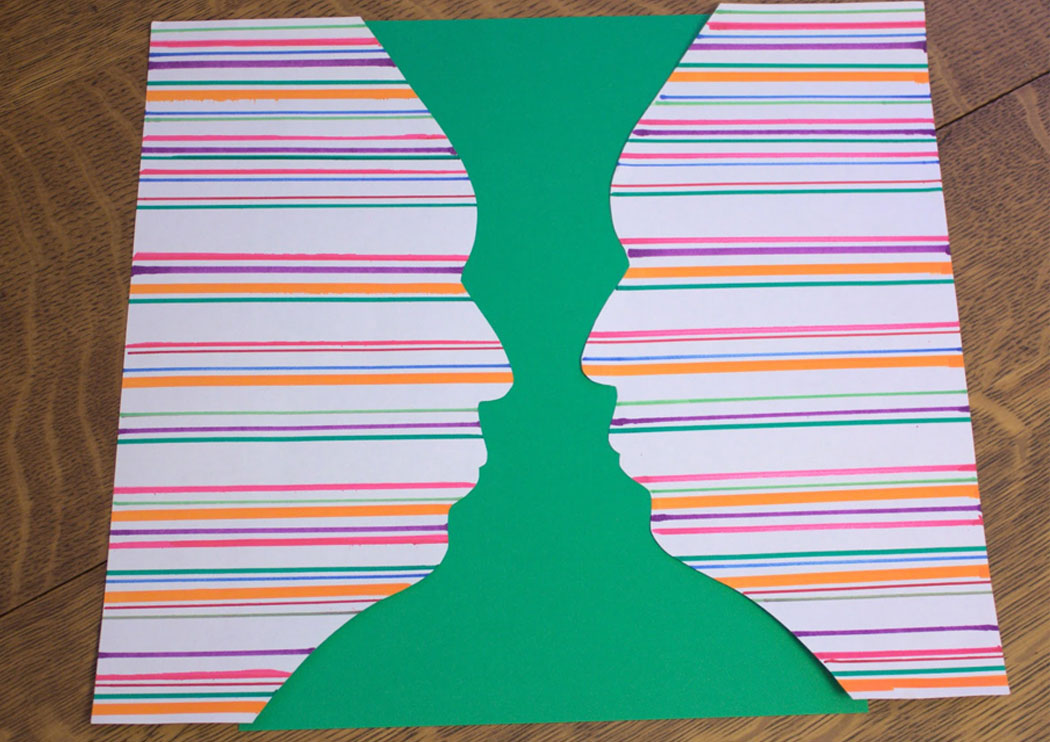 Paper silhouettes forming a vase between them