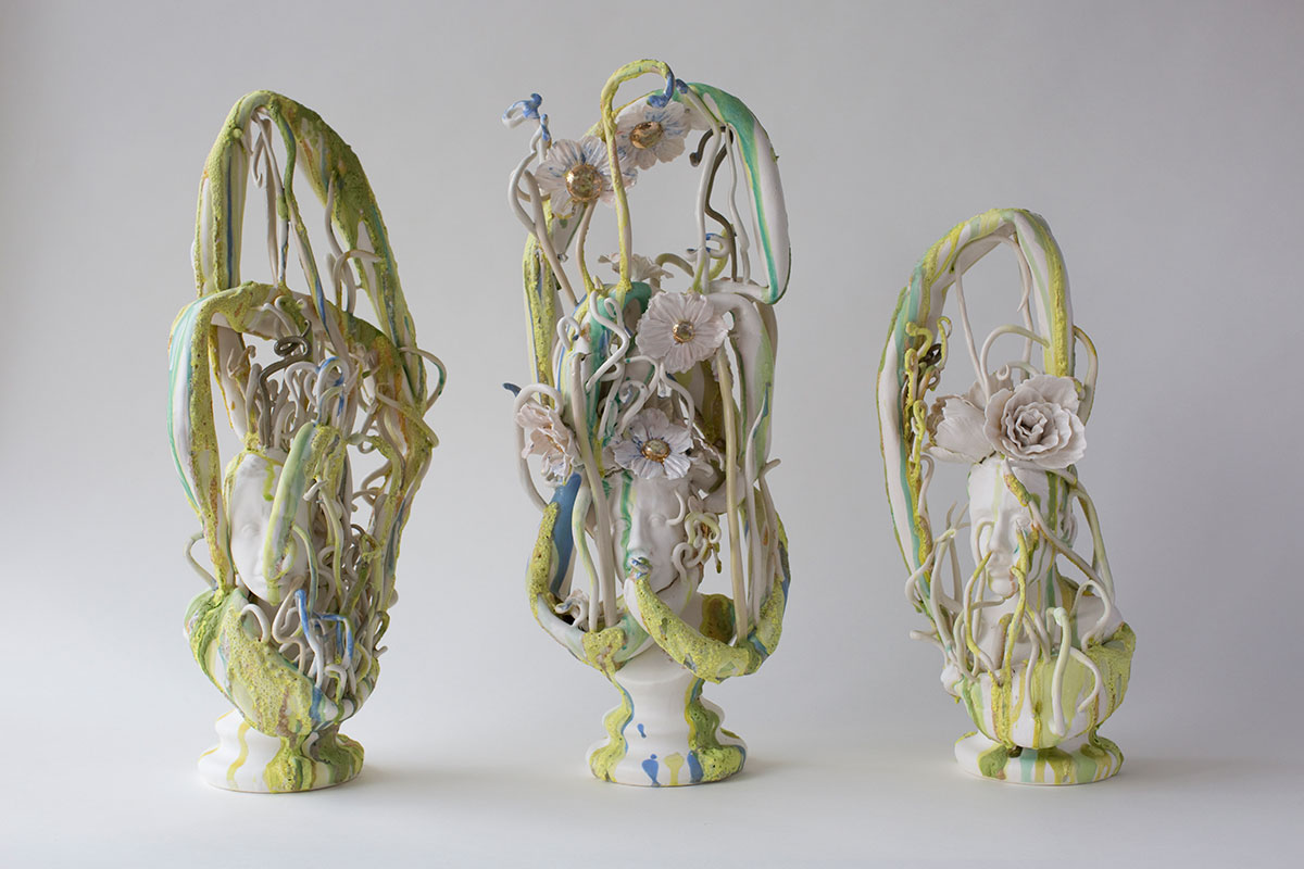 Three ceramic busts with floral elements winding around them