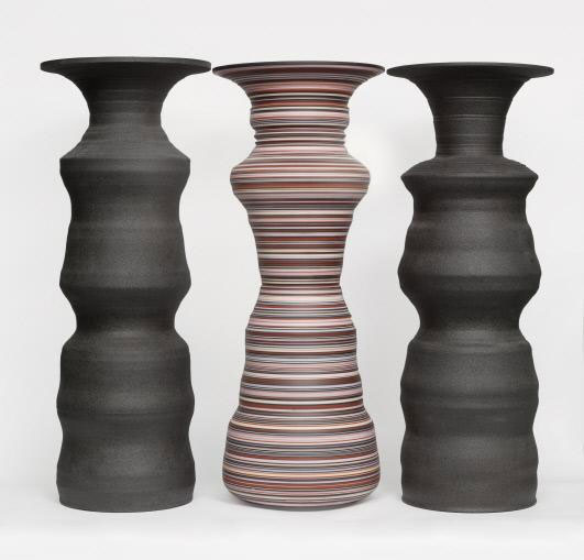 Ceramic vessels that create the silhouettes of two children in the negative space