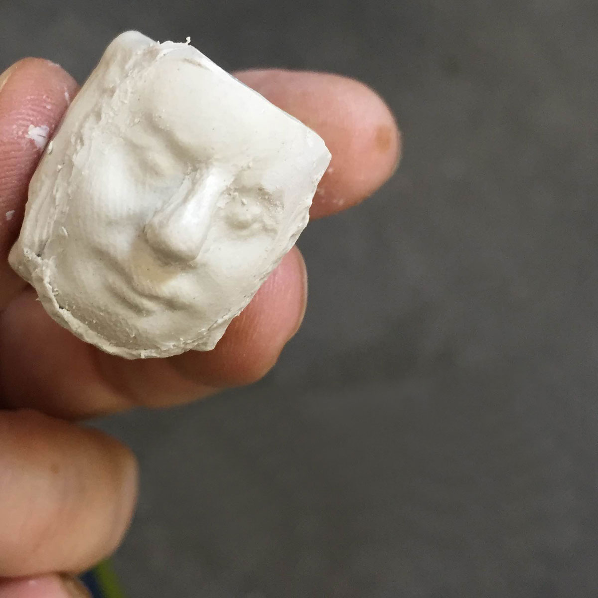 Hand holding clay head