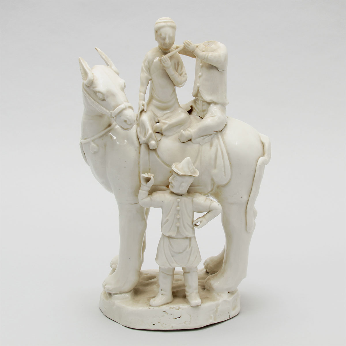 White porcelain figure of a horse and three men