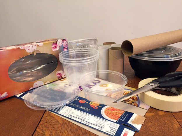 Art materials including paper towel rolls, a tissue box, and scissors