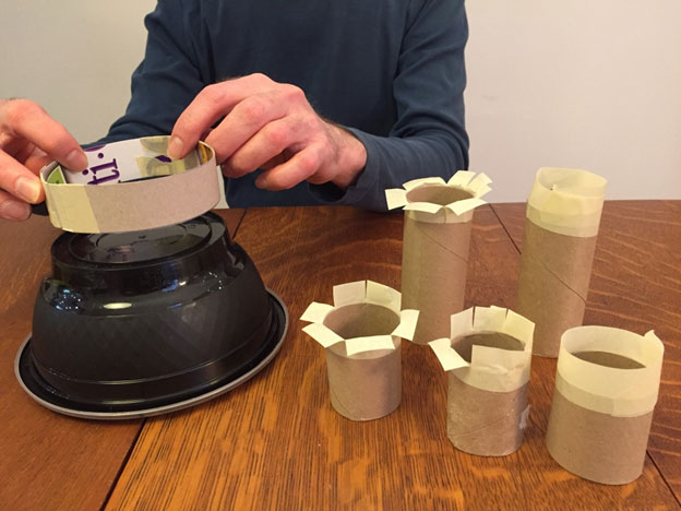 Taping a cardboard ring onto a plastic take out container