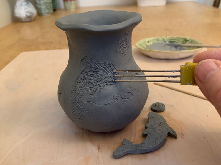 Scrating lines into a clay pinch pot