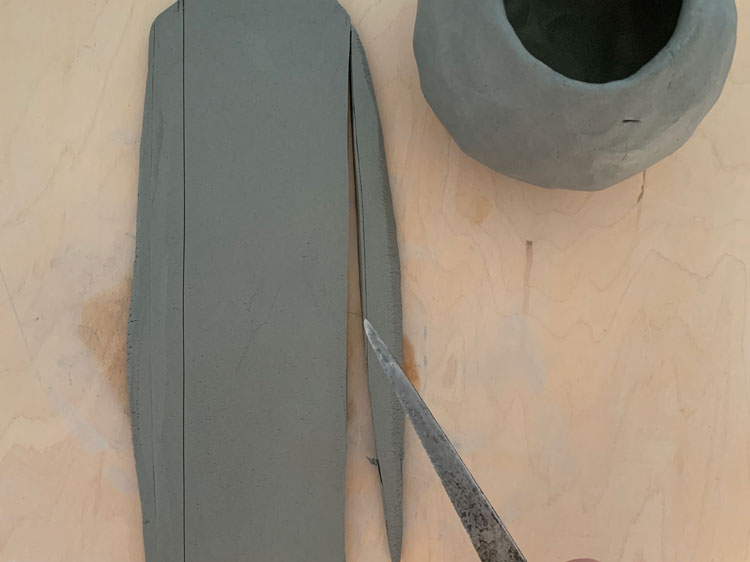 Cutting a piece of clay into a rectangle