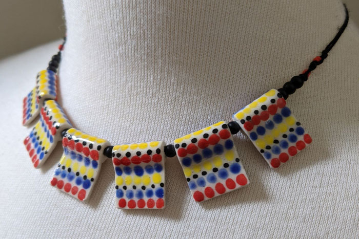 Necklace with square ceramic beads dotted with blue, red, and yellow glaze