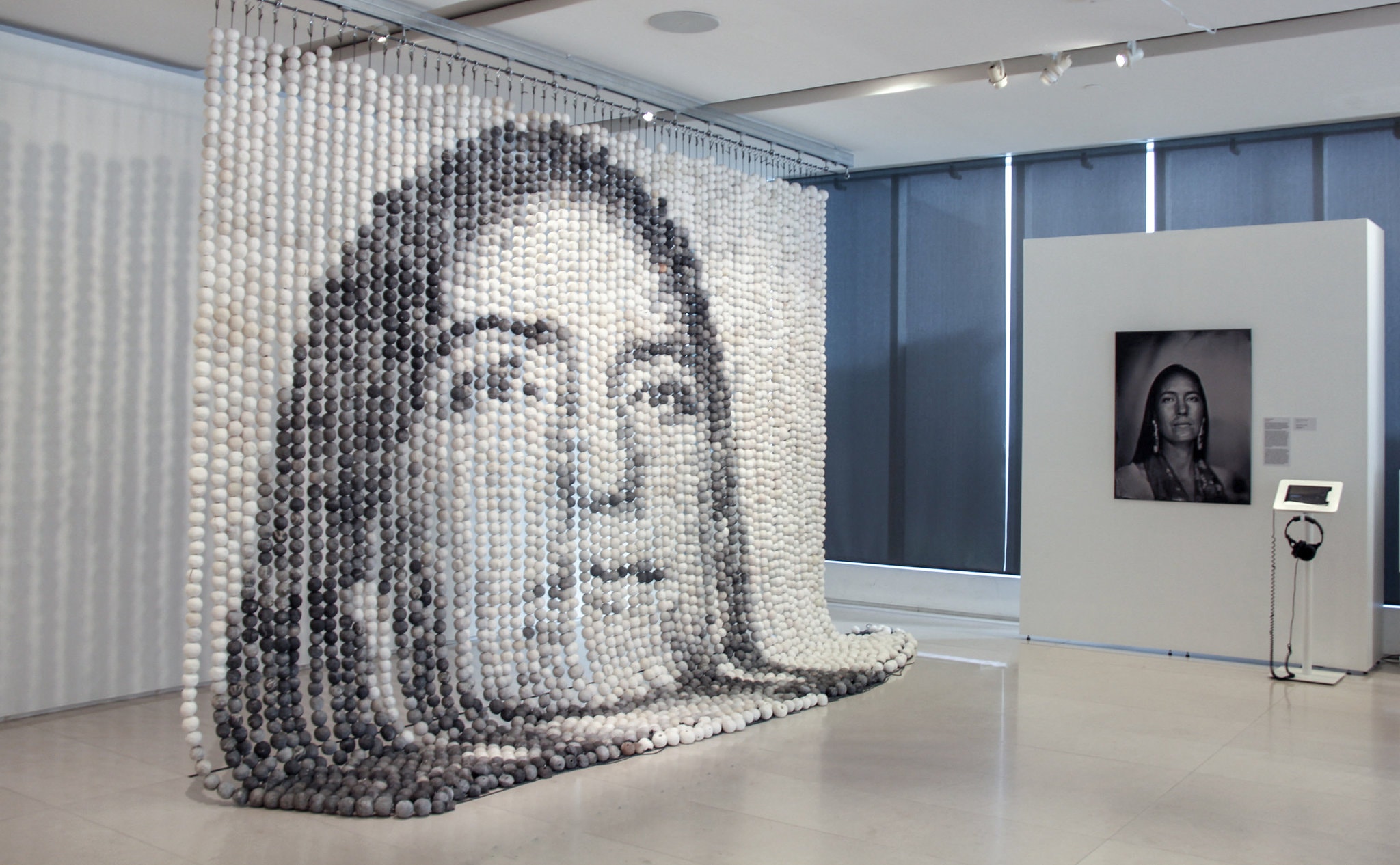 Ceramic bead curtain forming an image of a woman's face, next to the original photo of the woman