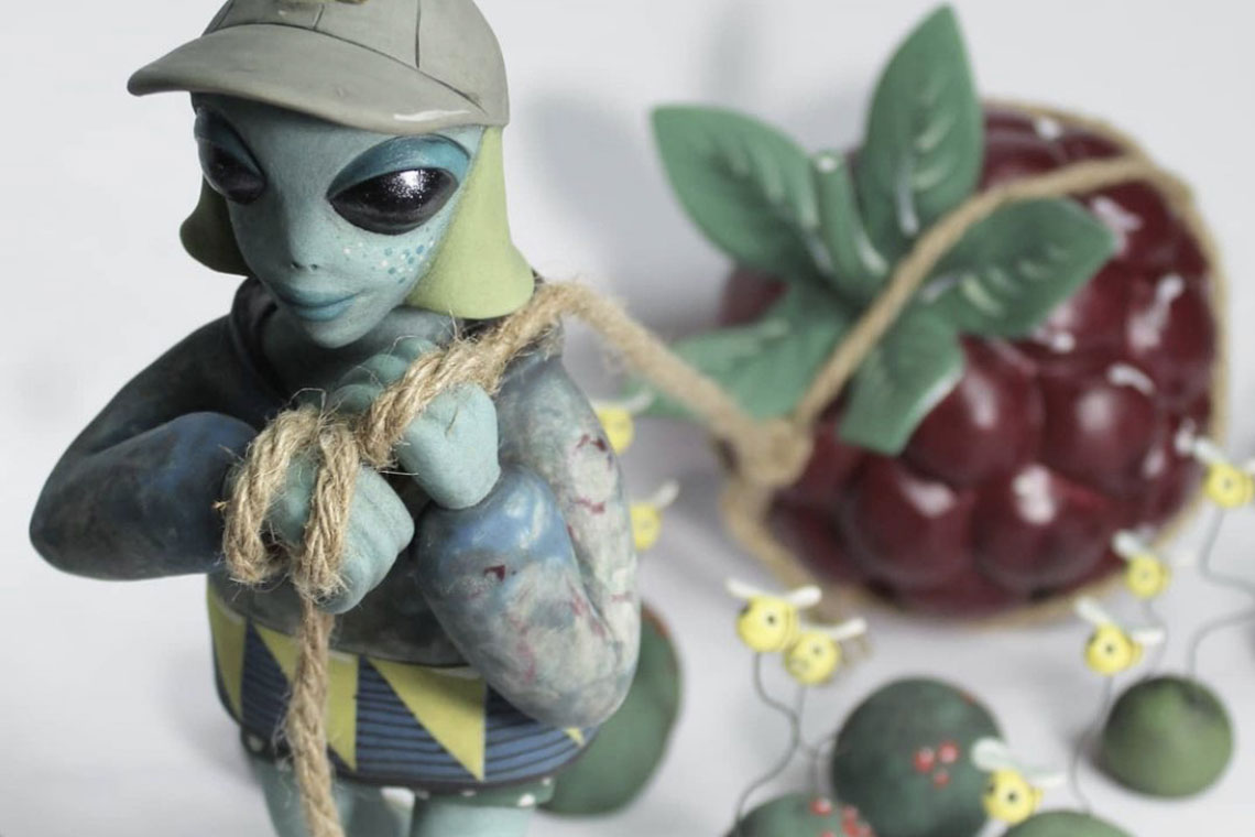 Ceramic alien pulling a berry on a string