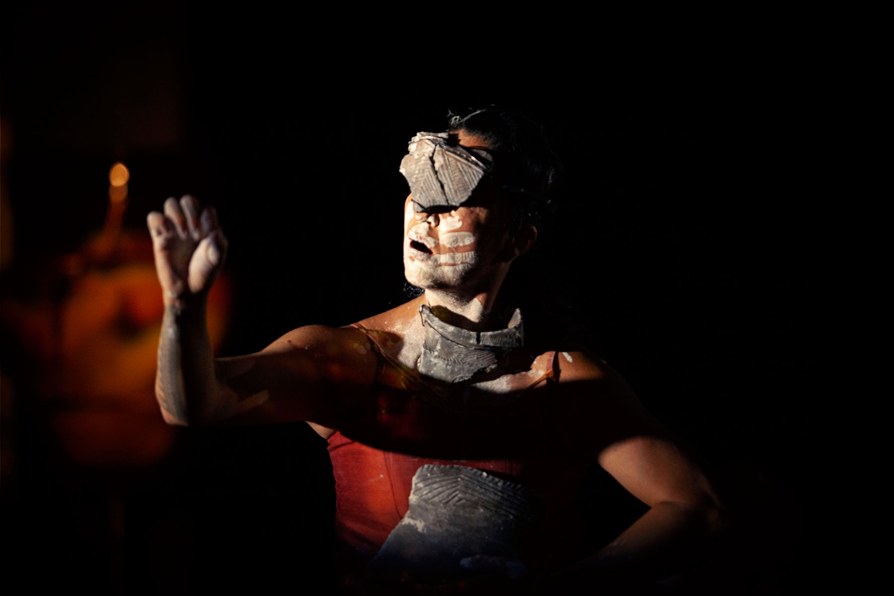An Indigenous dancer wearing a mask made of pottery
