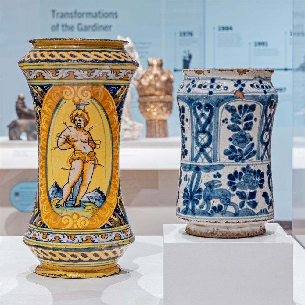 Two ceramic albarellos, one with a yellow background and figure of a saint and one with blue-and-white ornamentation