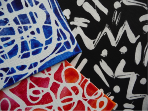 Three tiles painted with a paint resist method